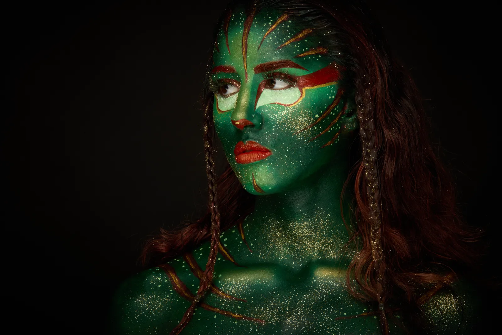 Body paint vert et or, regard de côté sur fond noir