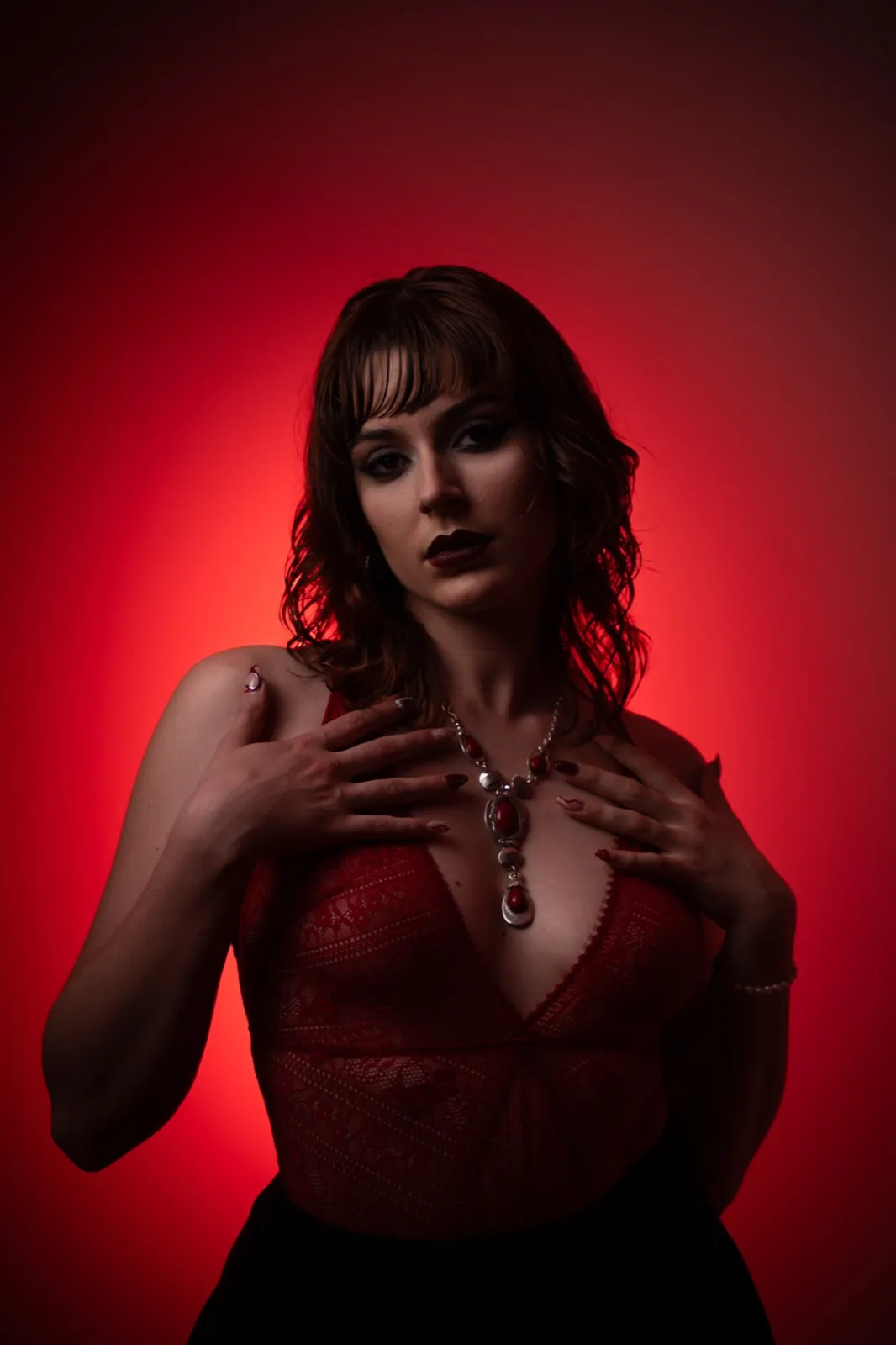 Portrait sous dominante rouge, mains croisées