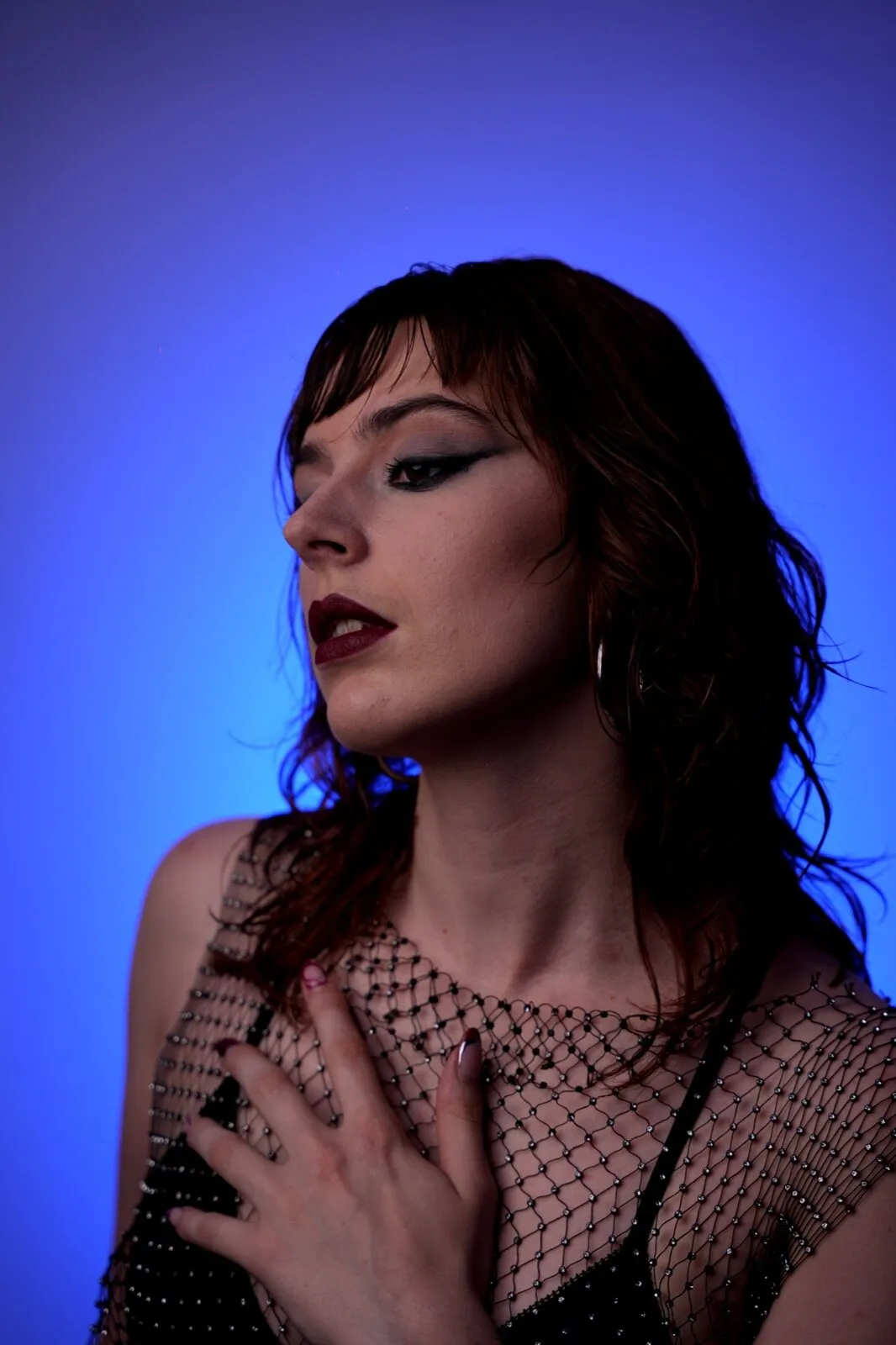 Profil sous fond bleu, trait d'eye-liner graphique